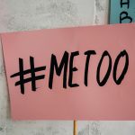 A close-up of a pink protest sign featuring the "#MeToo" message.