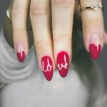 a woman's hand with a red and white manicure